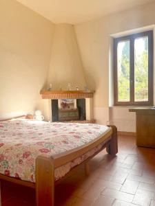 ein Schlafzimmer mit einem Bett und einem Kamin in der Unterkunft Podere San Giovanni in Pomaia