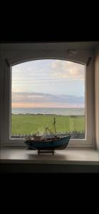 una ventana con un barco sentado en un alféizar de la ventana en Seaview Terrace en Skerries