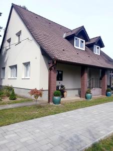 a white house with a brown roof at Summerside Apartman Harkány in Harkány