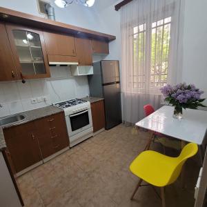 una pequeña cocina con mesa y silla amarilla en Family home, en Ereván