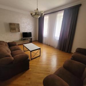 uma sala de estar com um sofá e uma mesa em Family home em Yerevan