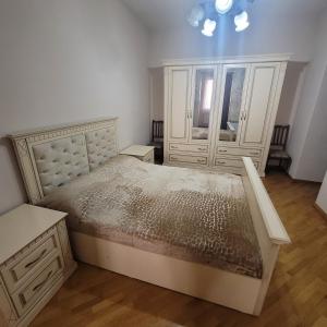 a bedroom with a large bed and two dressers at Family home in Yerevan