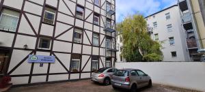 dos coches estacionados frente a un edificio en Hotel Am Sudenburger Hof, en Magdeburgo