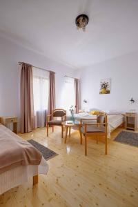 - une chambre avec un lit, une table et des chaises dans l'établissement Elimheim, à Cisnădioara