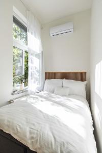 uma cama branca num quarto com uma janela em Modern Apartment French Balkony em Budapeste