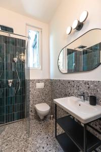 uma casa de banho com um lavatório, um WC e um espelho. em Modern Apartment French Balkony em Budapeste