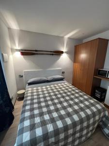 a bedroom with a bed with a checkered blanket at Wowies room in Pettenasco