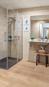 y baño con ducha acristalada y lavamanos. en Mood Bilbao Apartamentos - New & Special, en Bilbao