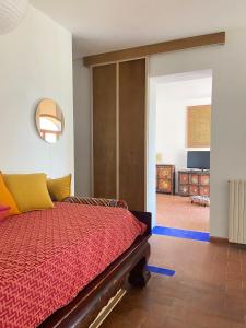 Schlafzimmer mit einem Bett mit einer roten Bettdecke in der Unterkunft Podere San Giovanni in Pomaia