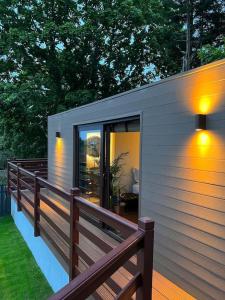 uma pequena casa com uma cerca e luzes sobre ela em Luxurious cabin with desk & mini library em Parkstone