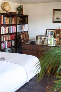 um quarto com uma secretária e uma estante de livros com livros em Luxurious cabin with desk & mini library em Parkstone