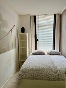 a bedroom with a bed in front of a window at Sea view Scheveningen in Scheveningen