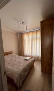 an empty bedroom with a bed and a window at Malina Guest House in Bosteri