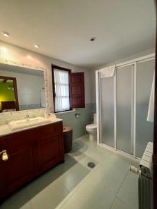 Un baño con lavabo, inodoro y espejo. en Casas Rurales Las Corradas, en Éndriga 37 fotos más