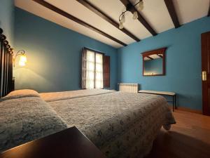 Un dormitorio con una cama grande con paredes azules. en Casas Rurales Las Corradas, en Éndriga