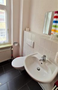 a bathroom with a sink and a toilet at Hotel Am Sudenburger Hof in Magdeburg