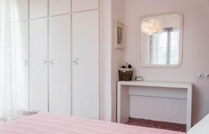 una camera da letto bianca con specchio e tavolo di Anna's Beautiful Apartment a Chania