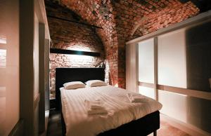 ストックホルムにあるOld Town Stay Hostelのレンガの壁にベッド1台が備わるベッドルーム1室