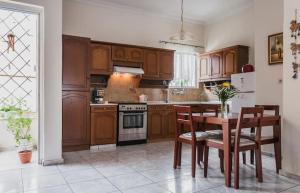 a kitchen with wooden cabinets and a table and chairs at Anna's Beautiful Apartment in Chania
