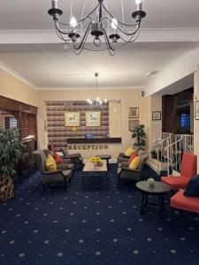 a hotel lobby with couches and chairs and a chandelier at Hadleigh Hotel in Eastbourne