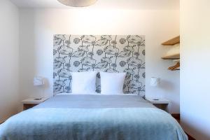 Schlafzimmer mit einem Bett mit blauer Tagesdecke in der Unterkunft D'un jour à l'autre in Banassac