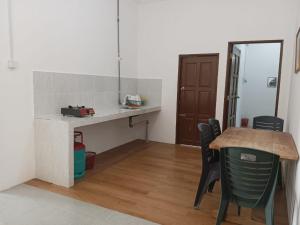 eine Küche mit einem Tisch und Stühlen im Zimmer in der Unterkunft Homestay Lembah Tambunan in Kampong Nail