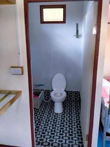 a bathroom with a toilet with a black and white floor at Phonphusang Utopia Farmstay 