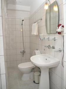 a white bathroom with a toilet and a sink at Melody City Otel in Alanya