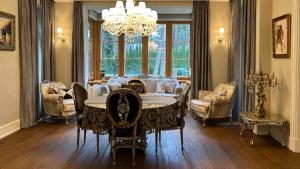 uma sala de jantar com uma mesa e cadeiras e um lustre em Stately Home in Magdalenka, nr Warsaw em Magdalenka