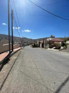 una calle vacía en una ciudad con montañas en el fondo en Al-Daar, en ‘Ayn Amūn