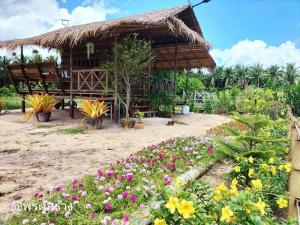 a small hut with flowers in front of it at Phonphusang Utopia Farmstay 