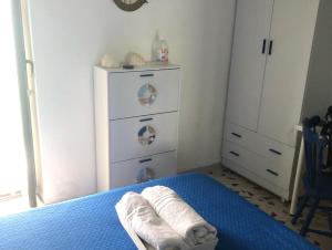 - une chambre avec un lit et une commode avec des serviettes dans l'établissement La Casetta sul mare di Cefalù, à Cefalù