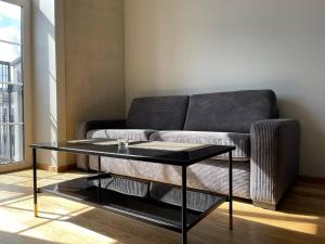 ein Wohnzimmer mit einem Sofa und einem Glastisch in der Unterkunft Center stay Kaunas - Peledyne - Owl's nest apartments in Kaunas
