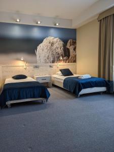 a bedroom with two beds and a rock wall at Hotel Morski Gdynia in Gdynia +40 photos