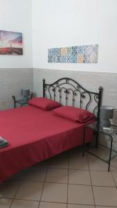 une chambre avec un lit avec un couvre-lit rouge dans l'établissement Casa di charme Bastioni, à Gallipoli