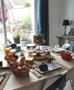 a table with bread and other food on it at Chambres d'hôtes aux portes de CHAMBORD in Vineuil