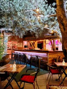 un restaurante con mesas y sillas y un bar en Les chalets du Relais d'Aguilar en Tuchan