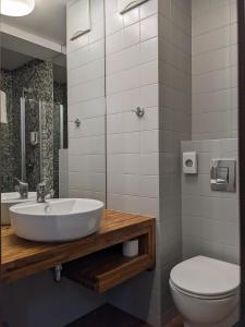 a bathroom with a sink and a toilet at Hotel Morski Gdynia in Gdynia