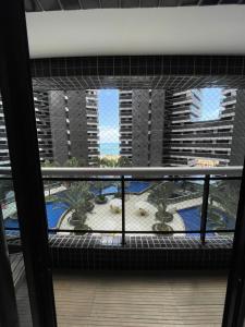 uma vista para uma varanda com palmeiras e edifícios em Landscape Beira Mar Fortaleza em Fortaleza