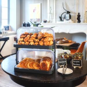 uma bandeja de produtos de pastelaria e croissants numa mesa em Hotel Napoleon em Île dʼAix