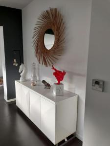 une armoire blanche avec un miroir sur le mur dans l'établissement Maison d'architecte avec SPA, à Concarneau
