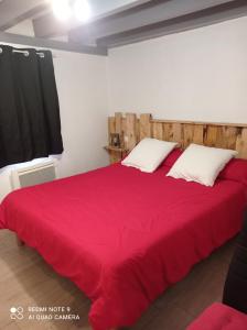 a bedroom with a large bed with a red blanket at Chalet Etxola in Ens
