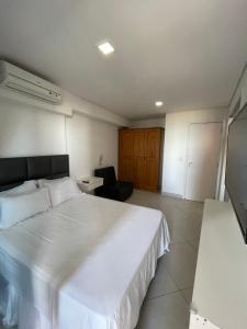 1 dormitorio con 1 cama blanca grande y 1 silla en Landscape Beira Mar Fortaleza en Fortaleza