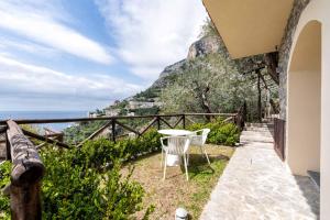 una mesa y sillas en un balcón con vistas al océano en Tenuta dell'Al.Ma. en Amalfi