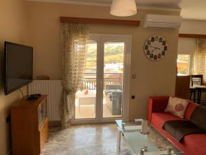 a living room with a couch and a tv at Panormo House in Panormos Rethymno