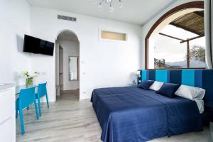 Un dormitorio con una cama azul y una mesa en Tenuta dell'Al.Ma., en Amalfi