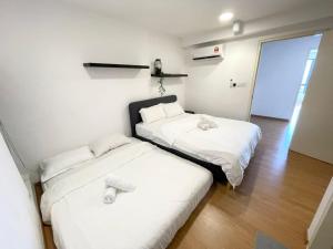 two beds in a room with white sheets at Minsu (Ekocheras) in Kuala Lumpur