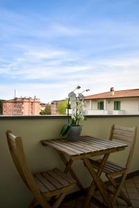 a wooden table and two chairs on a balcony at Orange Apartment in Marina di Massa