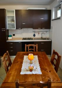 - une cuisine avec une table en bois et une bougie dans l'établissement Orange Apartment, à Marina di Massa