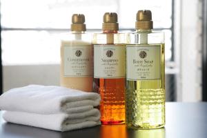 drie flessen essentiële oliën op een tafel met handdoeken bij goom Hotel Haruyoshi in Fukuoka